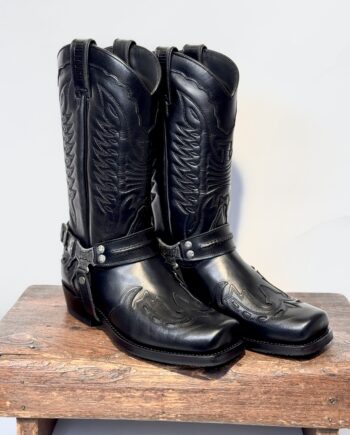 Flot sort højskaftet bikerboot i lækreste glatte okselæder med snirklede udskæringer, og dekorativ western stitching. Firkantet snude og aftagelig harness.