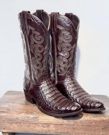 Flot og super eksklusiv cowboystøvle model Caiman, i chokoladebrun krokodilleskind på foden, og sammen farve okselæder på skaftet. . Dekoreret med flerfarvet broderi på skaft, klassisk buet skaft og afrundede snuder.